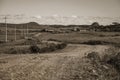 Dirt road passing through rural lowlands and ranch Royalty Free Stock Photo