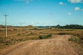 Dirt road passing through rural lowlands and ranch Royalty Free Stock Photo