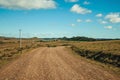 Dirt road passing through rural lowlands and ranch Royalty Free Stock Photo