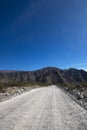 Dirt road perspective Tucuman Argentina valley calchaquies arid and dry with mountains rocks in Tafi del Valle conifers molles and Royalty Free Stock Photo