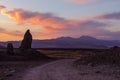 Dirt road running by tall pinnacle at sunset Royalty Free Stock Photo