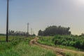 Dirt road in rural area next to power grid