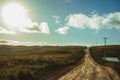 Dirt road in rural lowlands with sunlight