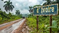 Dirt road with a sign to the cote d\'ivoire