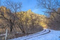 Dirt road in snowy Provo Canyon against mountain and blue sky in winter