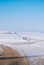 A dirt road to a frozen lake. Snowy Frozen road on a lake. Mountain is ahead of the icy road.