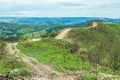 Dirt road on top of the hill surrounded by green nature. Royalty Free Stock Photo