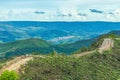 Dirt road on top of the hill surrounded by green nature. Royalty Free Stock Photo