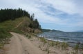 Dirt road and trail leading up the hill from Katun village along the Chivyrkuisky Bay of Baikal Lake Royalty Free Stock Photo