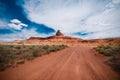 Dirt road trail leads to the Mexican Hat rock formation in the Utah desert