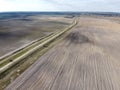 Dirt road between two plowed fields, aerial view. Agricultural land