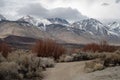Dirt road in winter landscape desert valley with snowy mountain peaks Royalty Free Stock Photo