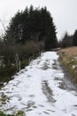 dirt road in winter, some parts are snow covered