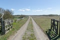 Dirt road with wooden gates by a great plain grassland at the swedish island Oland Royalty Free Stock Photo