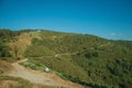 Dirt roads on hilly terrain covered by bushes and trees