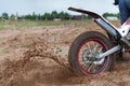 Dirt and sand fly from under rotating wheel of offroad motorcycle, action image, copy space Royalty Free Stock Photo