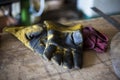 Dirtied welding gloves rest on table. Royalty Free Stock Photo