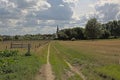 Dirtroad in the Flemish countryside with church in the distance