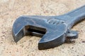 Dirty adjustable wrench on a cork background. Old spanner Royalty Free Stock Photo