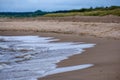 Dirty beach by the sea with storm clouds above in calm evening Royalty Free Stock Photo