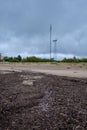 Dirty beach by the sea with storm clouds above in calm evening Royalty Free Stock Photo