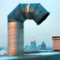 A dirty bended metal pipe on the roof of town