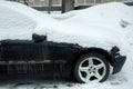 dirty black car side view, covered with snow. Royalty Free Stock Photo