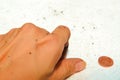 A dirty hand picking up coins on the white floor background. Royalty Free Stock Photo