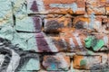 Dirty brick city wall, spattered with colorful spots of bright colors of aerosols Royalty Free Stock Photo