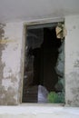 Dirty broken window frame with hole in center, sharp pieces of glass sticking out, concept shot, military operations, destruction