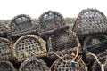 ends of lobster pots in a pile against a stone wall