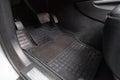 Dirty car floor mats of gray carpet with gas pedals and brakes in the workshop for the detailing vehicle before dry cleaning. Auto