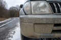 Dirty car headlights Adventure background. Detail of dirty off-road car Royalty Free Stock Photo