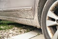 Dirty car with no mud flaps behind the car tire. Mud splashes on the car surface. Royalty Free Stock Photo