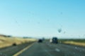 Dirty car window glass with insects and dirt affect driver visibility while driving on divided highway. The worn out or bad car