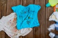 Dirty children`s clothes are scattered on a wooden table next to washing powders and soap.Concept washing dirty spots, the best Royalty Free Stock Photo