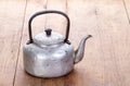 Dirty classic aluminum kettle on wooden background