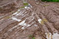 Dirty clay mud crossroads with puddles and tire tracks - close-up with selective focus and linear perspective Royalty Free Stock Photo