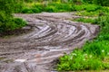 Dirty clay mud road zig-zag with puddles and tire tracks - closeup with selective focus Royalty Free Stock Photo