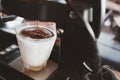 Dirty coffee, cold milk topped with a hot espresso shot drop from the machine Royalty Free Stock Photo