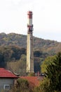 Dirty concrete tall red and white rectangle industrial chimney with two metal safety platforms and multiple cell phone antennas Royalty Free Stock Photo
