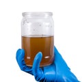 Dirty contaminated infectious water in a jar in hand rubber glove isolated on white