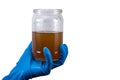 dirty contaminated infectious water in a jar in hand rubber glove isolated on white Royalty Free Stock Photo