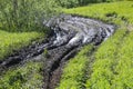 Dirty country road wet dirt, impassability. Mud and puddles on dirt road. Traces from tractors and cars. Royalty Free Stock Photo