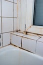 Dirty and damaged old porcelain bathroom tiles corner close up shot