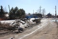 dirty dirt road to the house with puddles snow in the village for people in spring