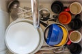 Dirty dishes in a ceramic kitchen sink. Unwashed plates, mugs and cutlery. Top view Royalty Free Stock Photo