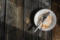 Dirty dishes.An empty dirty plate with the remains of food and sauce, a fork and a knife on a wooden table outside in a cafe.Flat Royalty Free Stock Photo