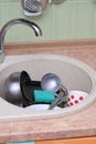 dirty dishes and kitchen utensils in a sink. messy kitchen. cluttered sink. daily routine, chores and housekeeping