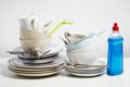 Dirty dishes pile needing washing up on white background